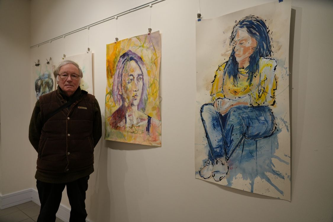 Mature student Roland Inman with his pictures in an art gallery.